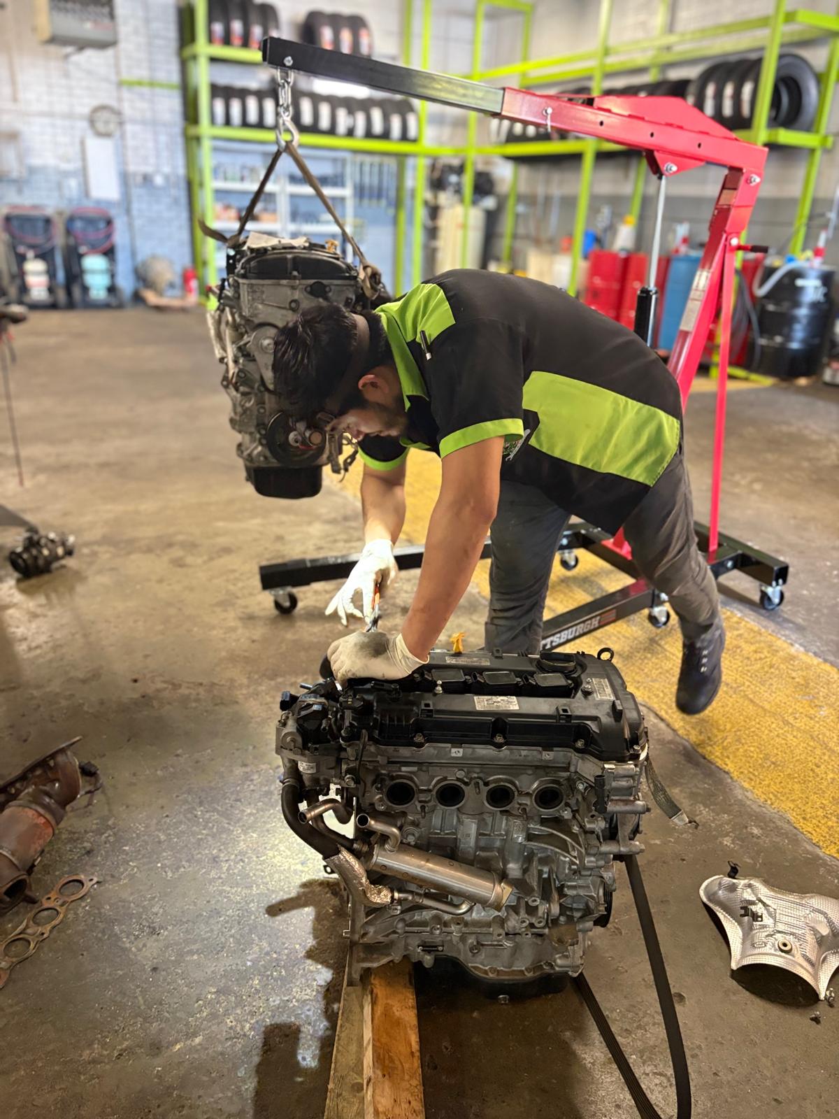 Mechanic cleaning engine components on a workbench